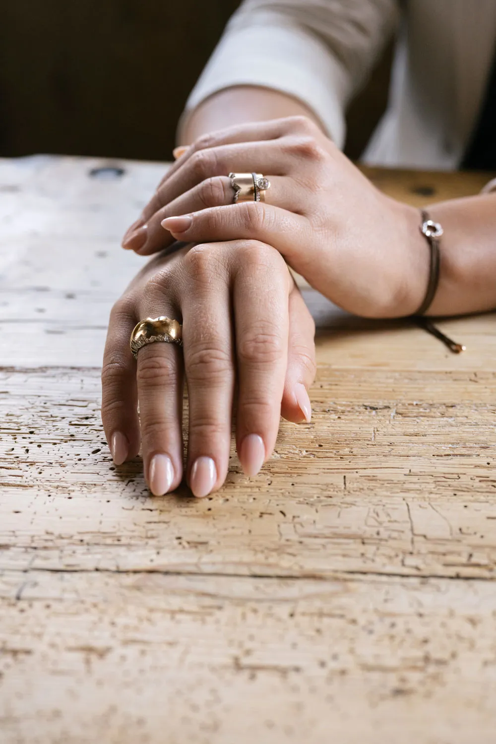 Dame mit goldenen Ringen und einem braunen Armband von Schmuckwerk